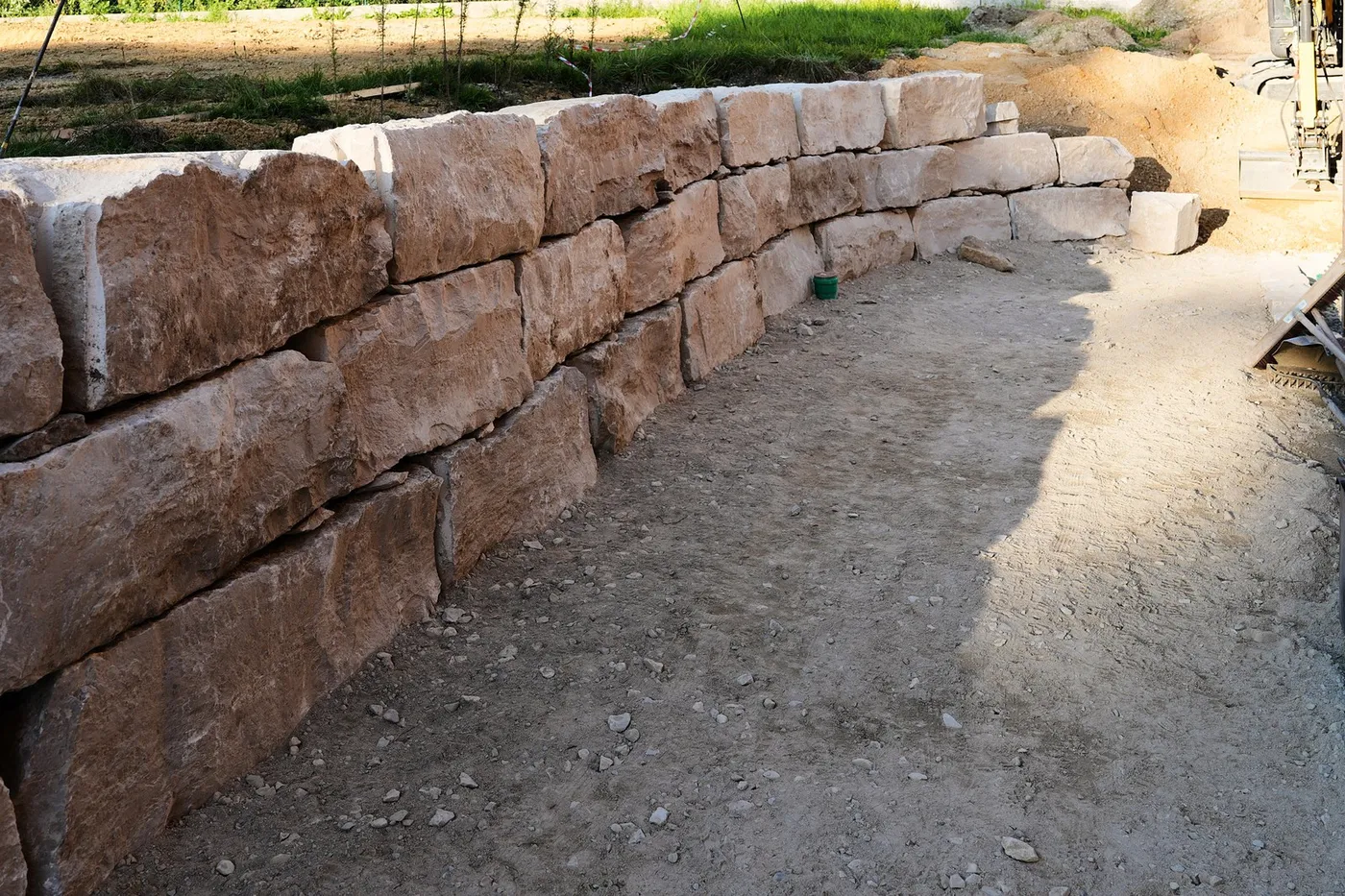 Mauer aus hellen Natursteinen im Bau