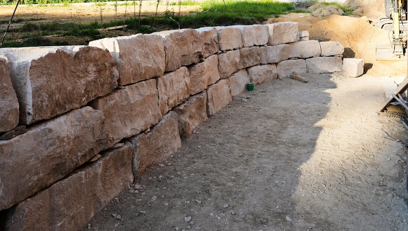 Trockenmauer aus Jurakalkstein neben einem wassergebundenen Weg beim Gartenprojekt in Bruckberg