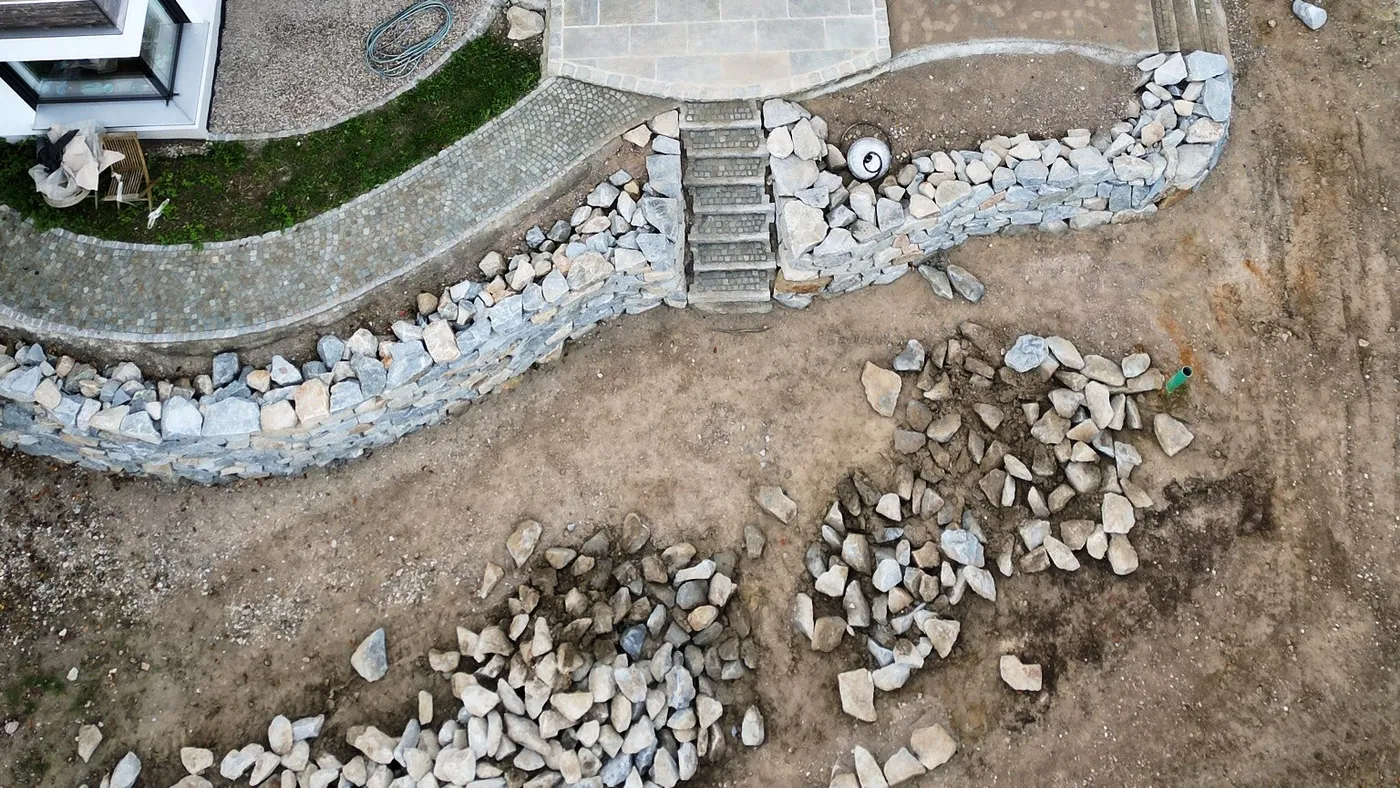 Blick von oben auf die Mauer und angrenzende Baufläche