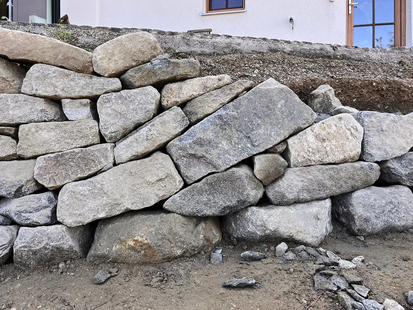Nahansicht unterschiedlich großer Granitsteine im Mauerverband