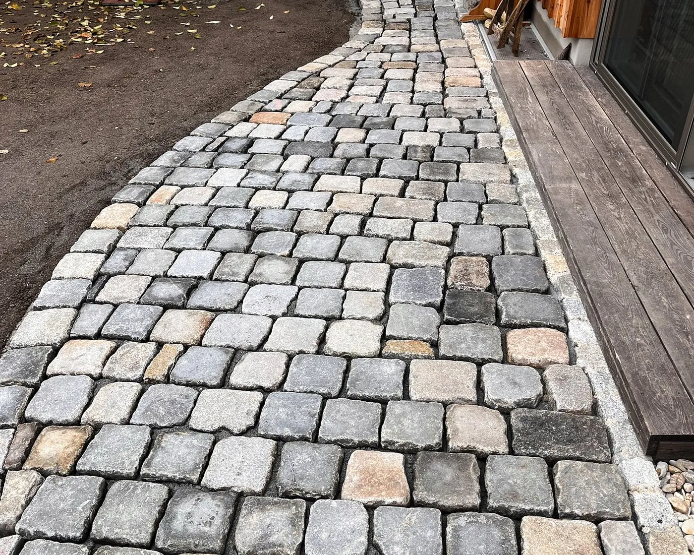 Granitpflaster während der Verlegung an einem Gebäude