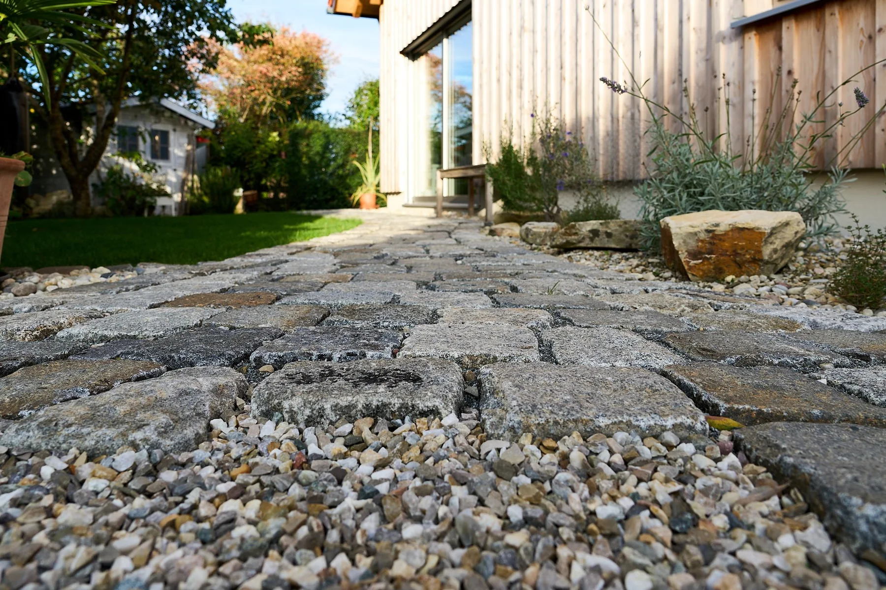 Sorgfältig gesetztes historisches Granitpflaster einer Gartenterrasse