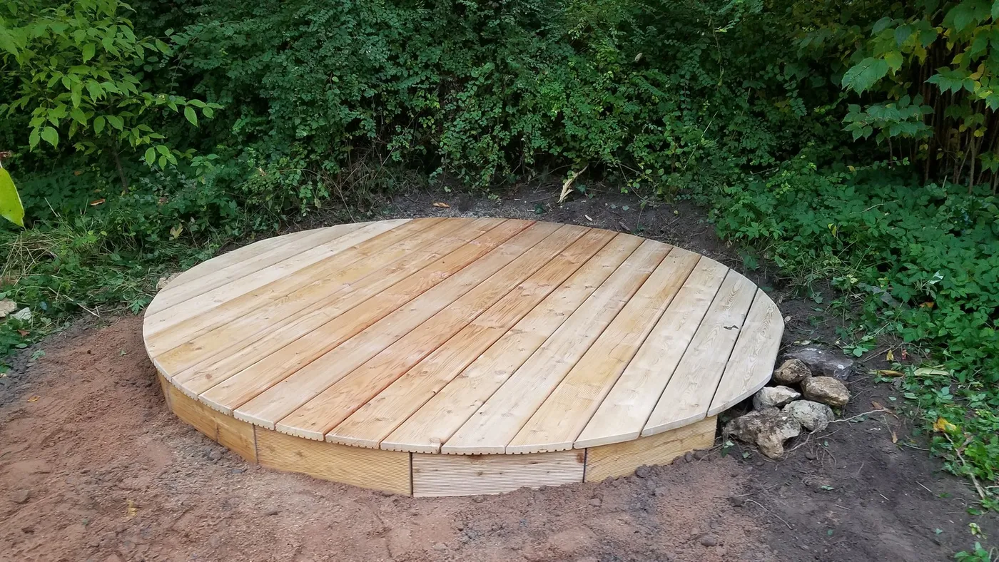 Rundes Holzdeck zwischen Gehölzen