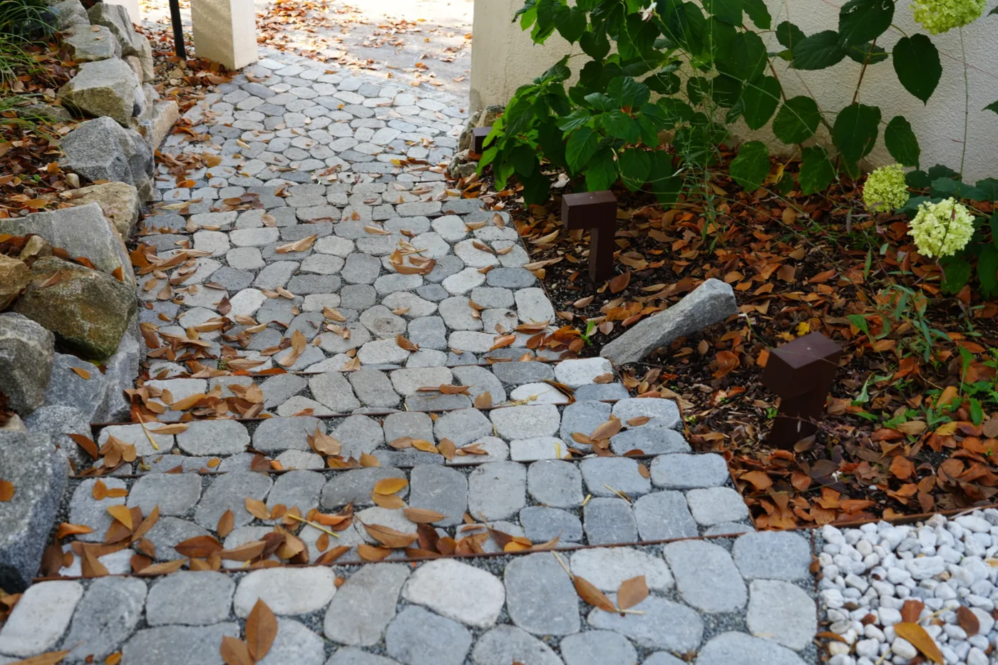 Blick von oben auf die neue Stufenfolge und den gepflasterten Gartenweg zwischen den Beetflächen